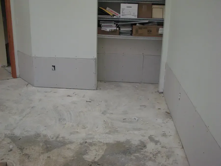 Open lower drywall and exposed floor during structural drying